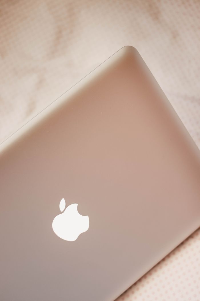 From above of modern design netbook with smooth glowing surface on creased bed sheet in daylight in house